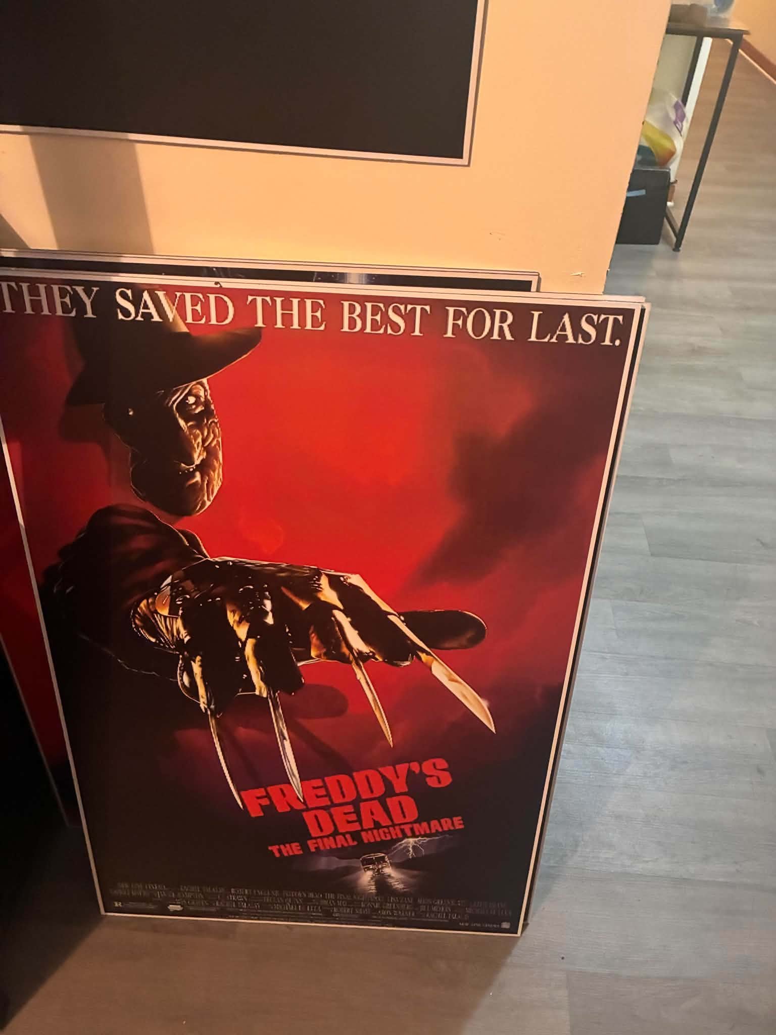 Photo of a Freddy's Dead: The Final Nightmare poster print with Freddy Krueger's clawed glove reaching out of red smoky air