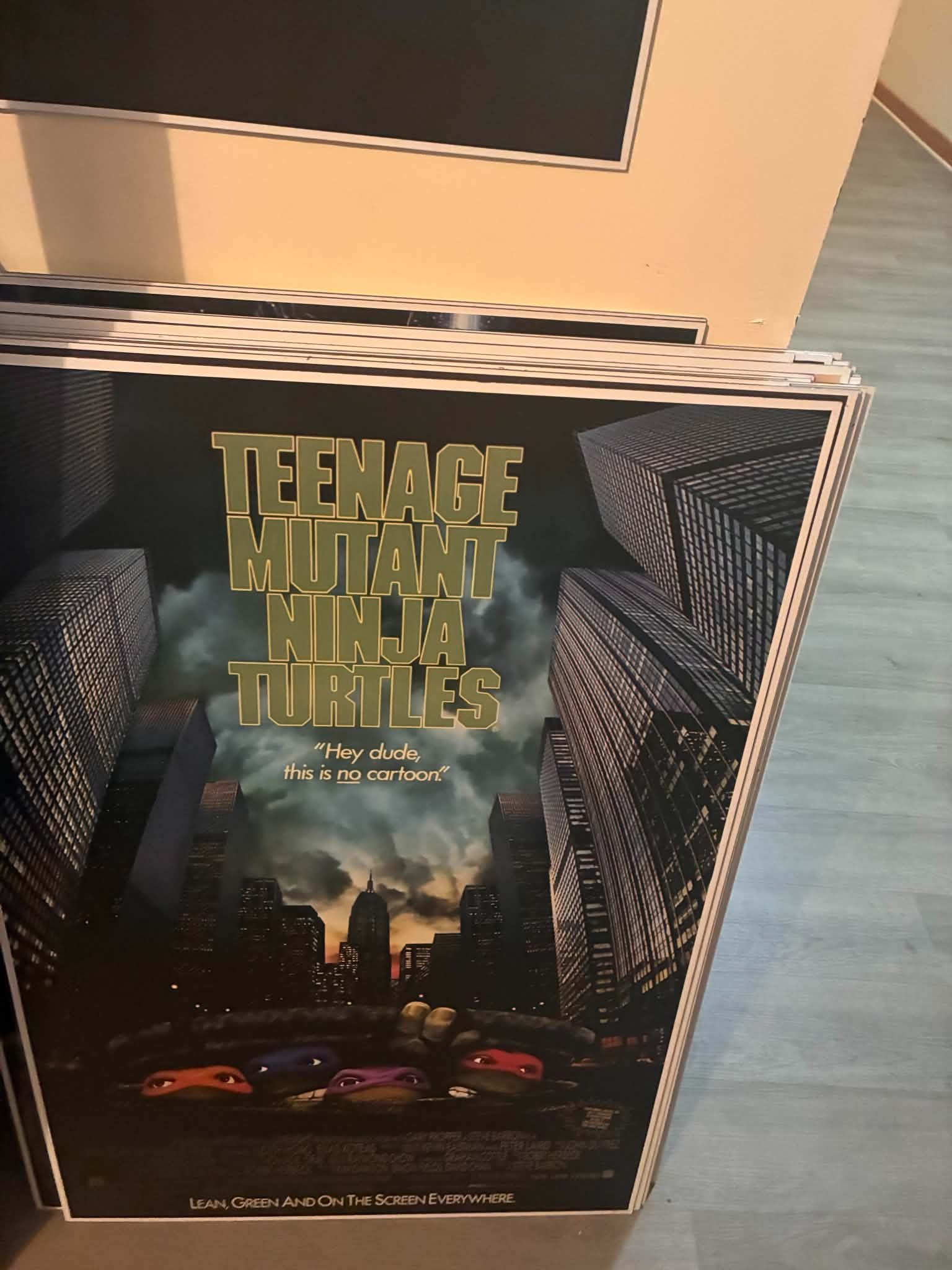 Photo of the 1990 Teenage Mutant Ninja Turtles poster print with all four turtles rising from a manhole before the New York skyline at sunset