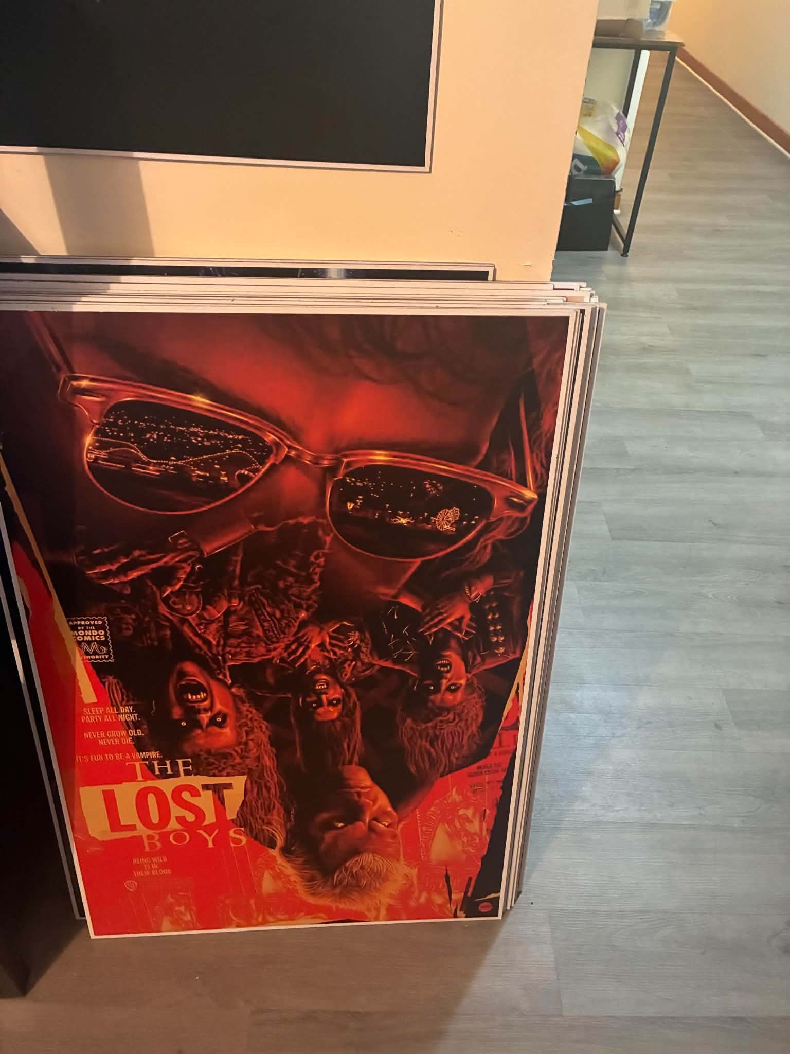 Photo of a comic-book-style The Lost Boys poster print with the vampire pack faces reflected in a pair of sunglasses
