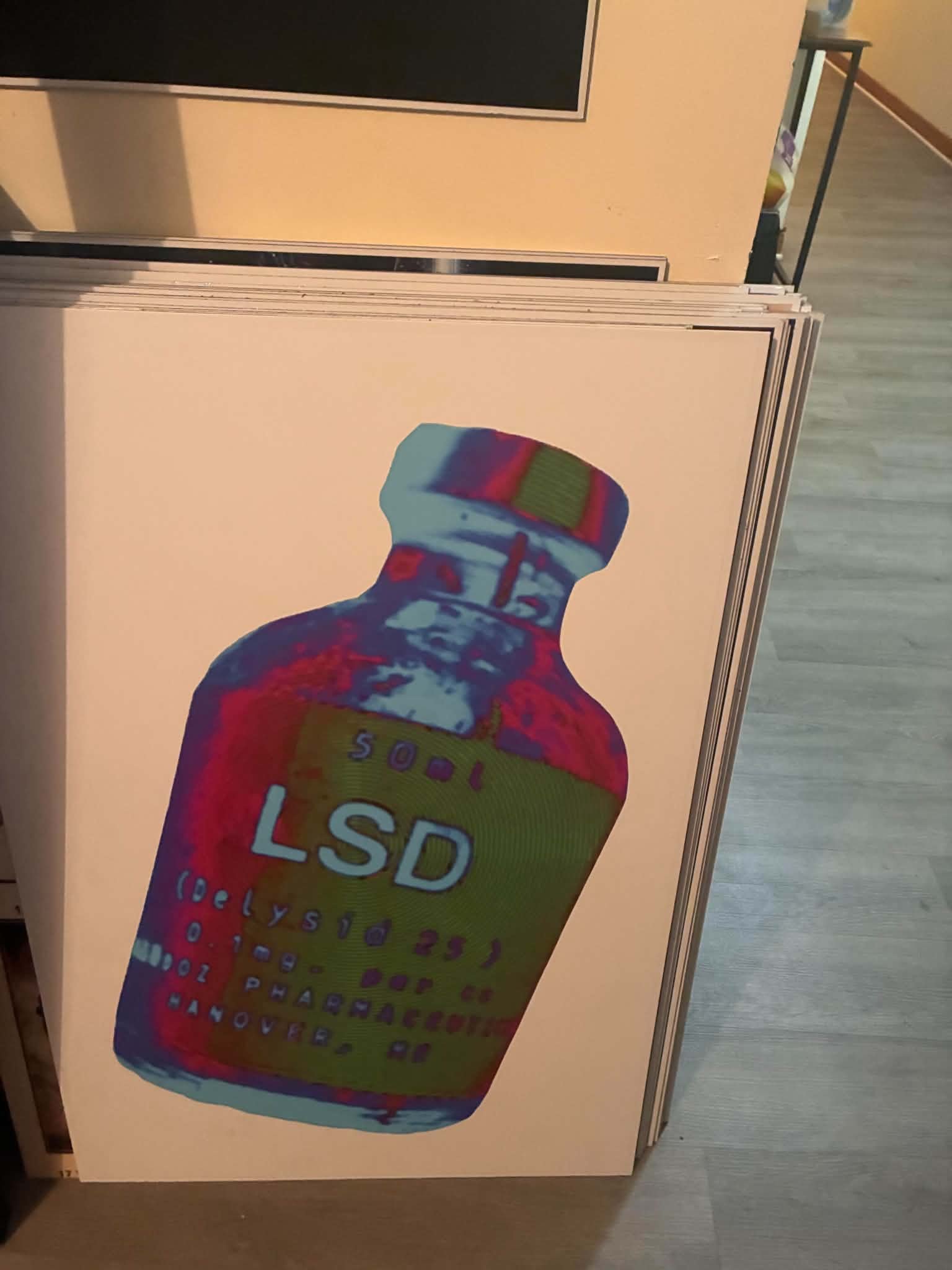 Photo of a psychedelic pop-art print of a vintage Delysid sample bottle in blue, red, and green